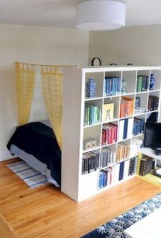 a room with a bed, bookshelf and desk