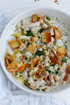 a white bowl filled with food sitting on top of a blue and white table cloth