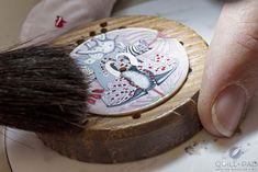 a close up of a brush on top of a white plate with an artistic design