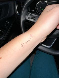 a person with a tattoo on their arm driving a car