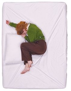 a man laying on top of a white mattress