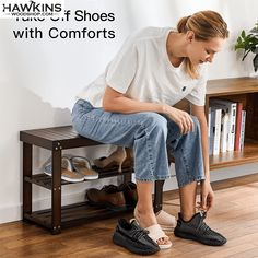 a woman sitting on top of a wooden bench in front of a book shelf with shoes