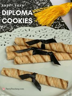 three pieces of bread on a white plate with black ribbon and tassels tied around the edges