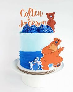 a cake with blue frosting and bears on the top that says, caterh & jackson