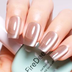 a woman's hand with a manicured nail polish in beige and silver tones