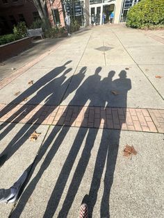 the shadow of two people standing next to each other in front of an apartment building