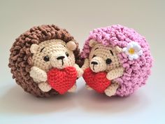 two crocheted teddy bears holding a heart