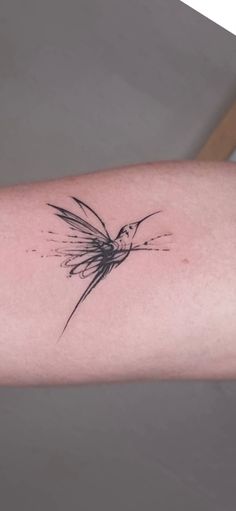 a small tattoo on the arm of a woman's arm with a bird flying over it