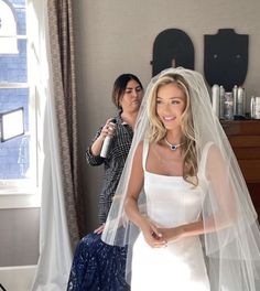 the bride is getting ready to walk down the aisle in her wedding dress and veil