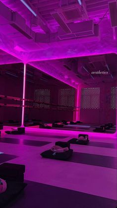 an empty gym with purple lighting in the ceiling