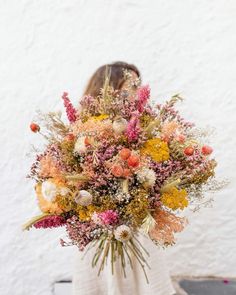 a woman holding a large bouquet of flowers