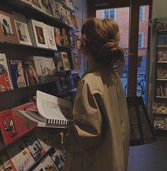 a woman is looking at books in a bookstore