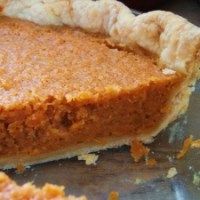 a piece of pie sitting on top of a metal pan next to an orange peel