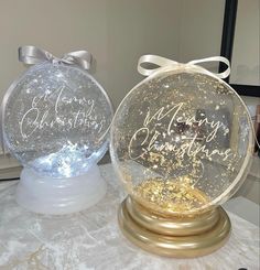 two snow globes sitting on top of a table