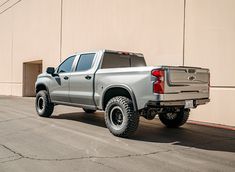 a silver truck parked in front of a building