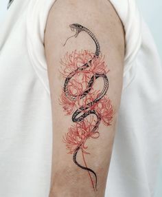 a woman's arm with a snake and flowers tattoo design on the left upper arm