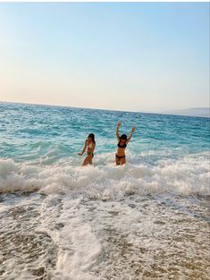 two women in bikinis playing in the ocean