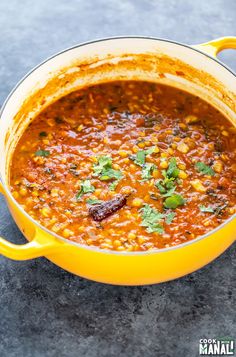 a yellow pot filled with beans and cilantro on top of a countertop