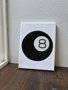 a black and white monogrammed letter b on a canvas next to a window