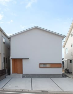 a white building with wooden doors on the front and side of it's sides