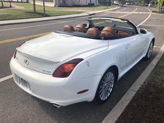 a white convertible car parked on the side of the road