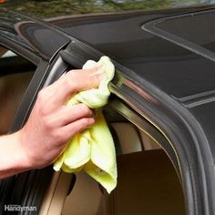 a person is cleaning the outside of a car with a microfibrel cloth