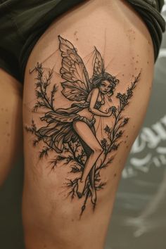 a woman's thigh with a tattoo design on the leg and a fairy sitting on it