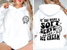 a woman sitting on a bed wearing a white hoodie with black lettering that says if you want a soft serve, go get ice cream