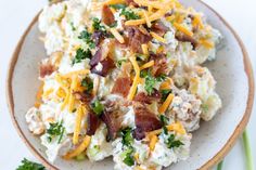 a white plate topped with potato salad and bacon