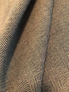 a close up view of a blue and brown herringbone pattern on a suit fabric