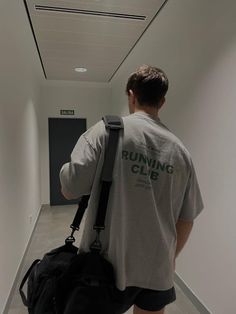 a man with a back pack walking down a hallway