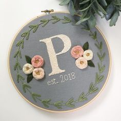 embroidered monogrammed wall hanging with flowers and greenery