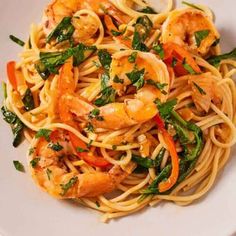 pasta with shrimp and spinach in a white bowl