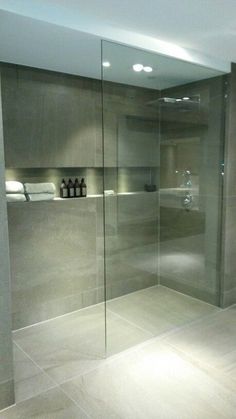 a bathroom with a walk in shower next to a tiled floor and white counter top