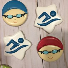 three decorated cookies are sitting on a table next to each other, one is wearing glasses and the other has a hat