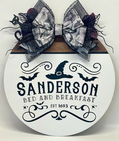 a sign that says sanders bed and breakfast with a large bow on it's head