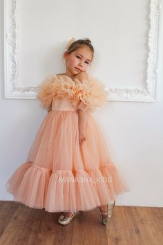 Enhance your little one's special occasion attire with our exquisite sleeveless children's festive dress. Made from shimmering tulle, this floor-length gown features a tulle ruffle hem, adding an extra touch of elegance. The bodice is embellished with tulle ruffles, bringing a whimsical charm to the shoulders and top of the dress. Finished with a delicate tulle bow at the back, this dress is perfect for any celebration, ensuring your little princess feels truly enchanting. I am here to assist yo Sweet Tulle Dress For First Birthday, Kids Tulle Dress, Whimsical Ruffled Dress For First Birthday, First Birthday Fairy Dress With Ruffles And Tulle, Pink Tool Toddler Dress, Photo Shoot Dress, Pink Tulle Toddler Dress, Birthday Party Girl, Festive Dress