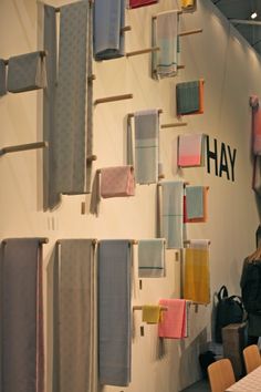 a woman standing in front of a wall with towels hanging on it