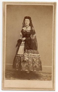 an old photo of a woman wearing a dress