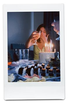 two people sitting at a table with a cake in front of them and candles on it