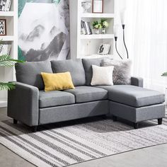 a living room with a gray couch and yellow pillows