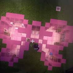 an aerial view of a house with pink squares on the floor and green grass around it