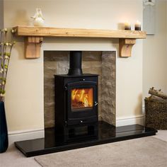 a wood burning stove in a living room next to a fireplace mantel and rug