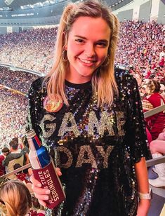 "Get ready to rock your game day in style with this \"Game Day\" tunic dress! 🏈🎉 This fabulous frock is all about showing off your team spirit, and guess what? FREE shipping is on the house for orders over $35, so you can gear up without breaking a sweat! 💃 ✨ Front Sequins Only: Just like your passion for the game, the sequins on this tunic dress are front and center, ensuring you're the star player without any sequin discomfort on the back. Wear It Your Way: This short-sleeved sensation is a one-size-fits-most for all you sports enthusiasts ranging from S to L. It's a versatile piece you can rock as a dress or a chic long top, making it the ultimate choice for game day celebrations. You'll be the MVP of style with a comfy oversized fit and those effortlessly stylish dropped shoulders. Saints Game Day Outfit, Football Gameday Outfit, Football Jersey Dress, Black And Gold Sequin Dress, Sequin T Shirt, Sequin T Shirt Dress, Tailgate Outfit, College Apparel, Girls 21st