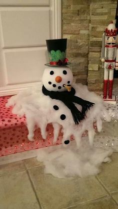 a snowman sitting on top of a pile of foam next to a door way