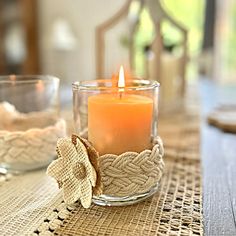 a candle sitting on top of a table next to a glass bowl filled with water