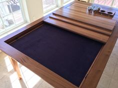 a wooden table with two cups on it and a blue mat in front of the table