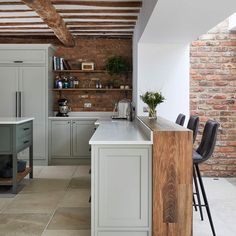 a kitchen with an island and brick wall