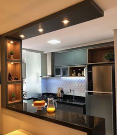 a modern kitchen with stainless steel appliances and black counter tops, along with built - in shelving