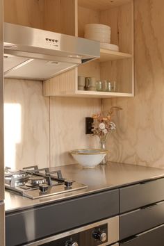 a stove top oven sitting inside of a kitchen next to a counter with bowls on it